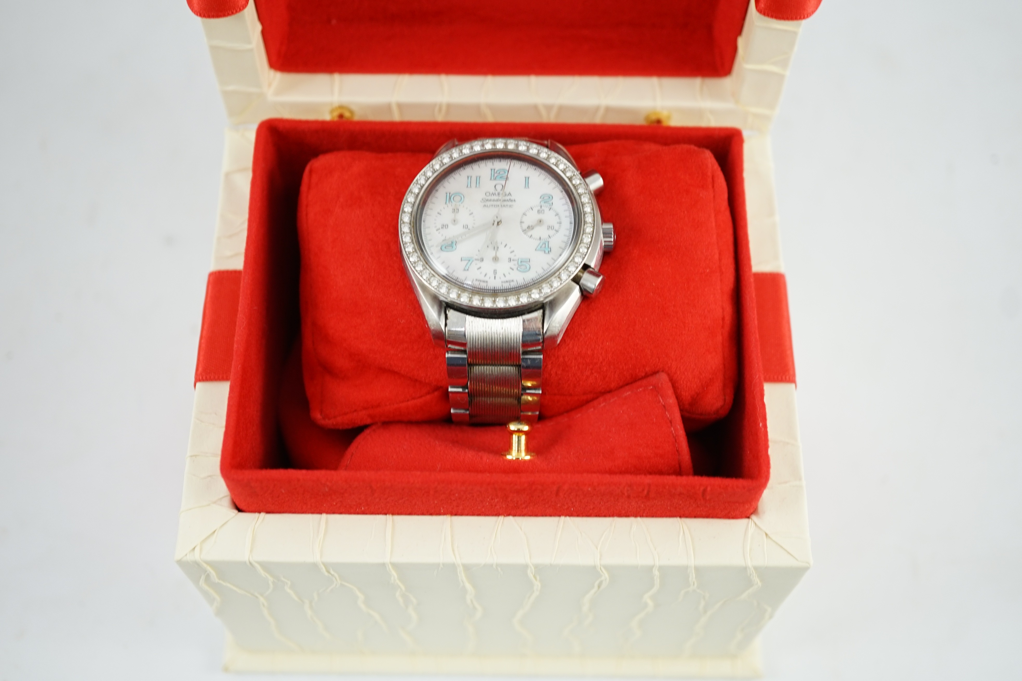 A lady's modern stainless steel Omega Speedmaster automatic wrist watch and bracelet, with mother of pearl Arabic dial and diamond set bezel